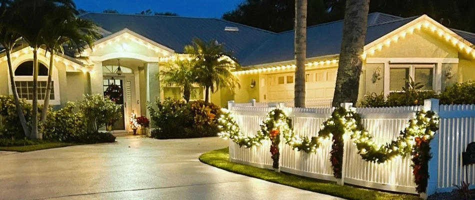 A home in New Smyrna Beach, FL, with white christmas lights on the home and fence.