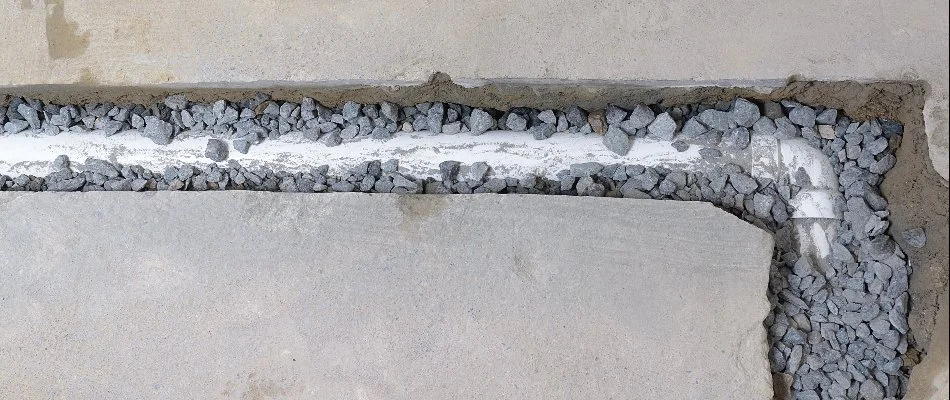 A French drain in New Smyrna Beach, FL, in concrete with rocks.